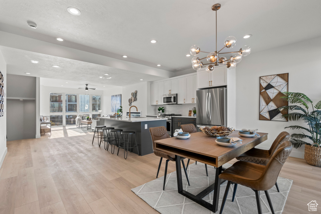 Dining space featuring light wood-style floors, recessed lighting, and a chandelier