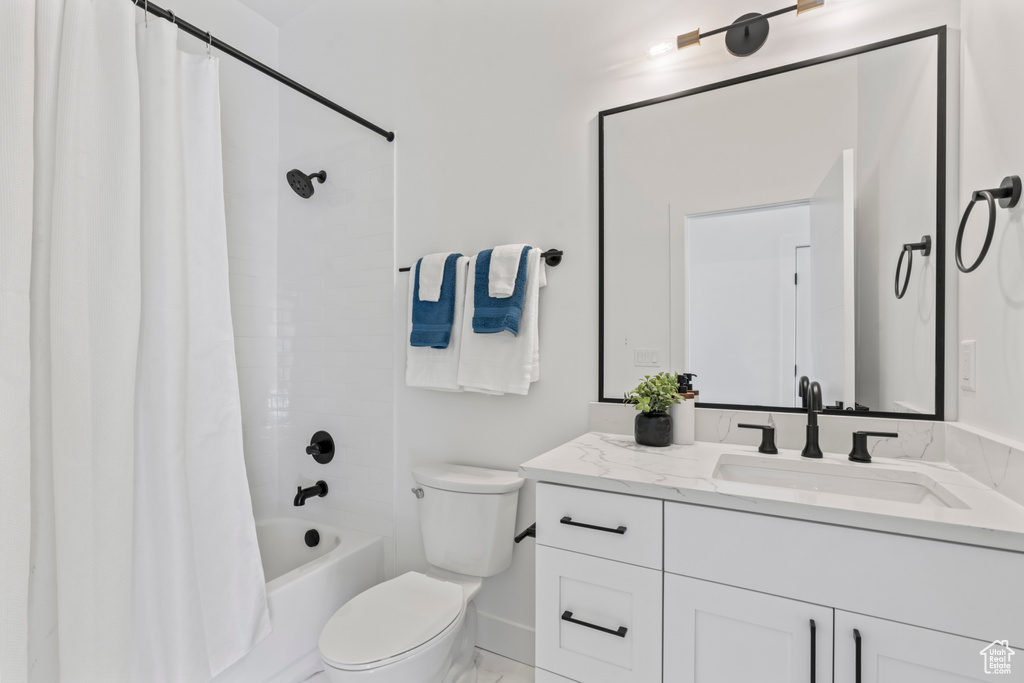 Bathroom featuring vanity and shower / bath combination with curtain