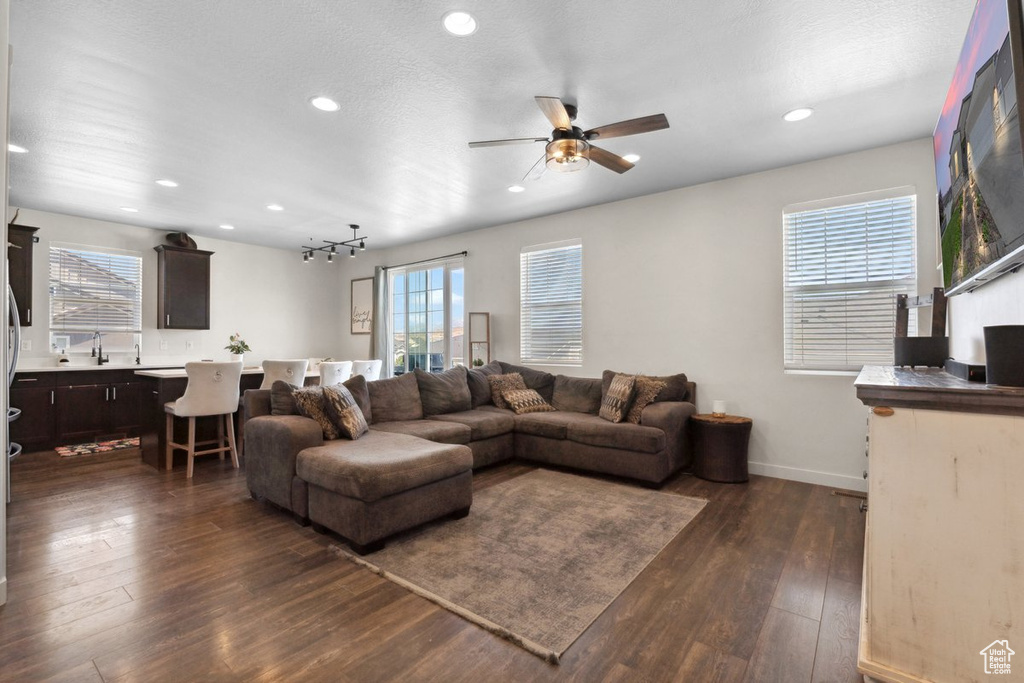 Living area with ceiling fan, recessed lighting, and dark wood-style flooring