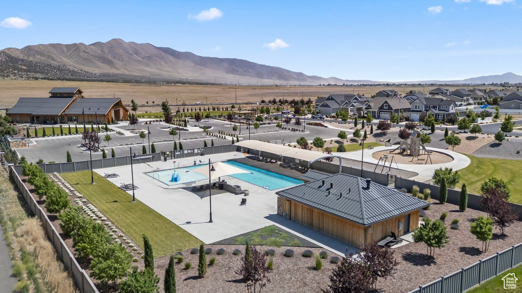 Aerial view of residential area featuring a pool and mountains