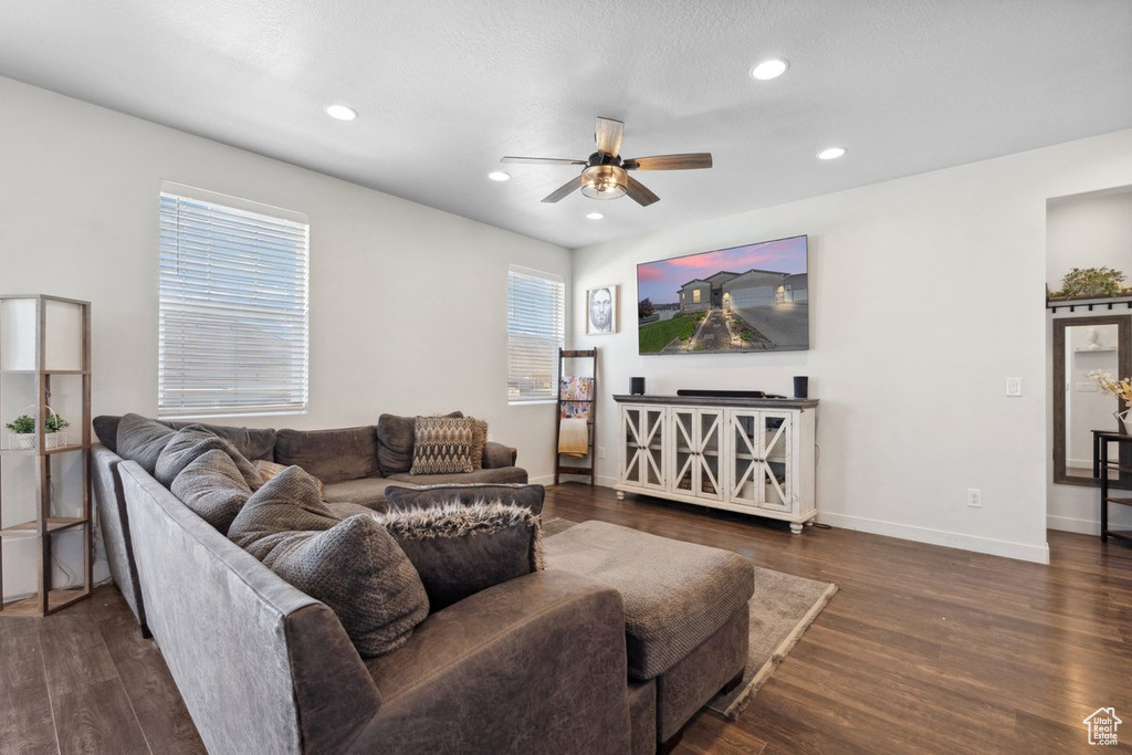 Living area with a ceiling fan, dark wood-style floors, and recessed lighting