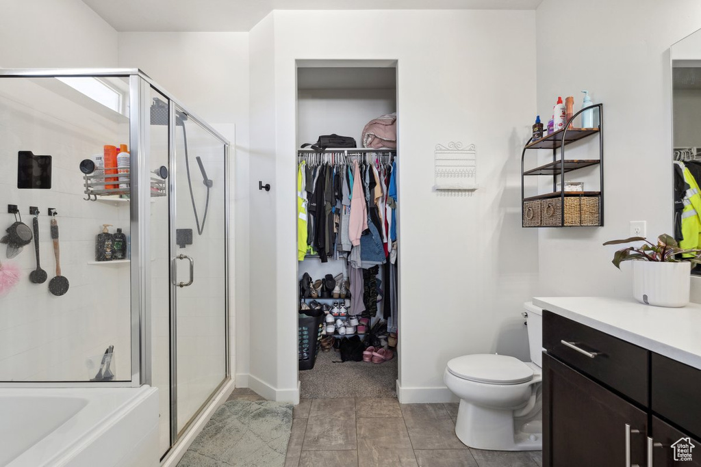 Full bath featuring a shower stall, vanity, and a walk in closet