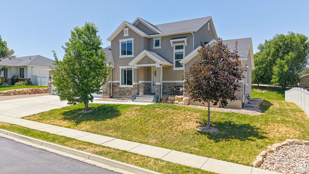 Craftsman inspired home with stone siding, stucco siding, and driveway