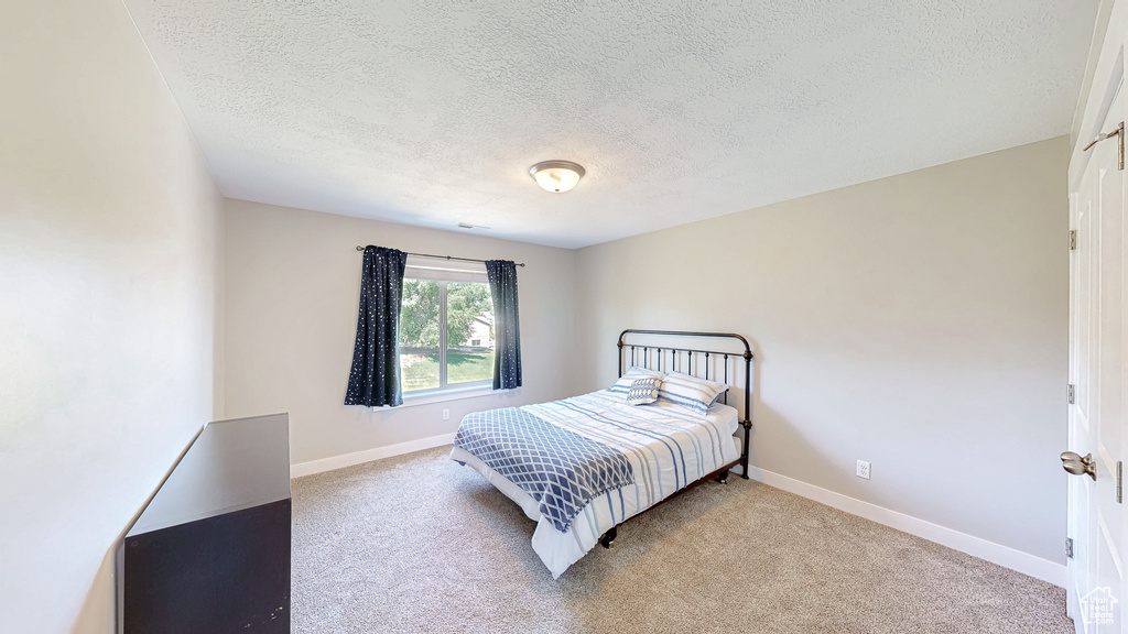 Bedroom featuring a textured ceiling and carpet