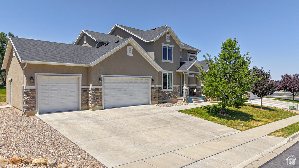 Craftsman-style house with stone siding, an attached garage, stucco siding, a shingled roof, and driveway