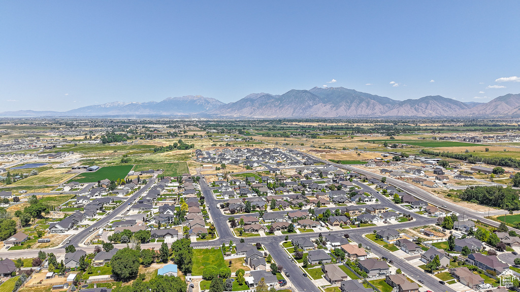Aerial view of property and surrounding area with mountains and nearby suburban area