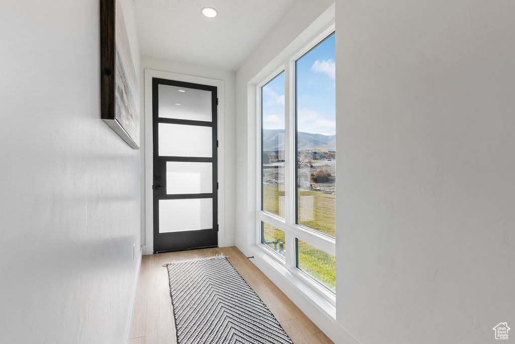 Doorway to outside featuring a mountain view, light wood-style floors, and recessed lighting