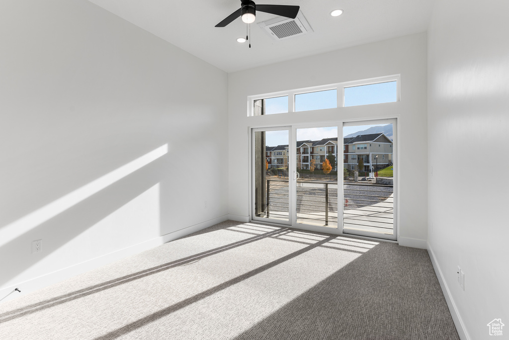Carpeted spare room featuring ceiling fan and recessed lighting
