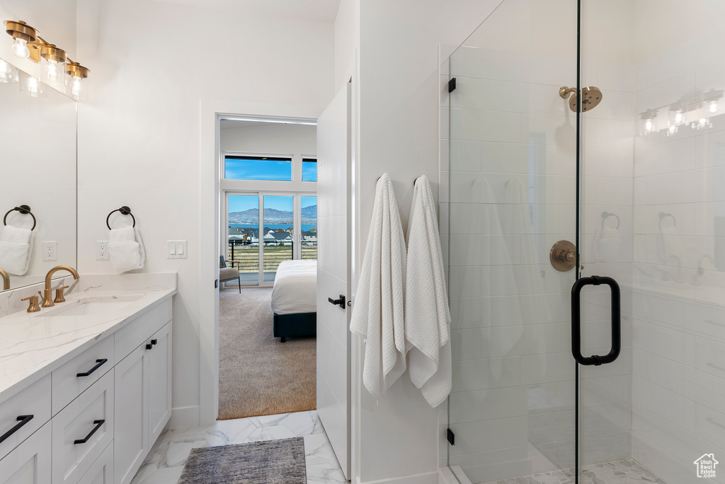 Ensuite bathroom with a stall shower, vanity, baseboards, and marble finish floors