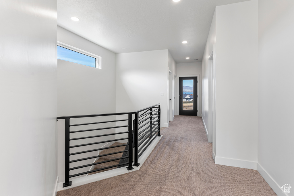 Corridor featuring an upstairs landing, carpet, and recessed lighting