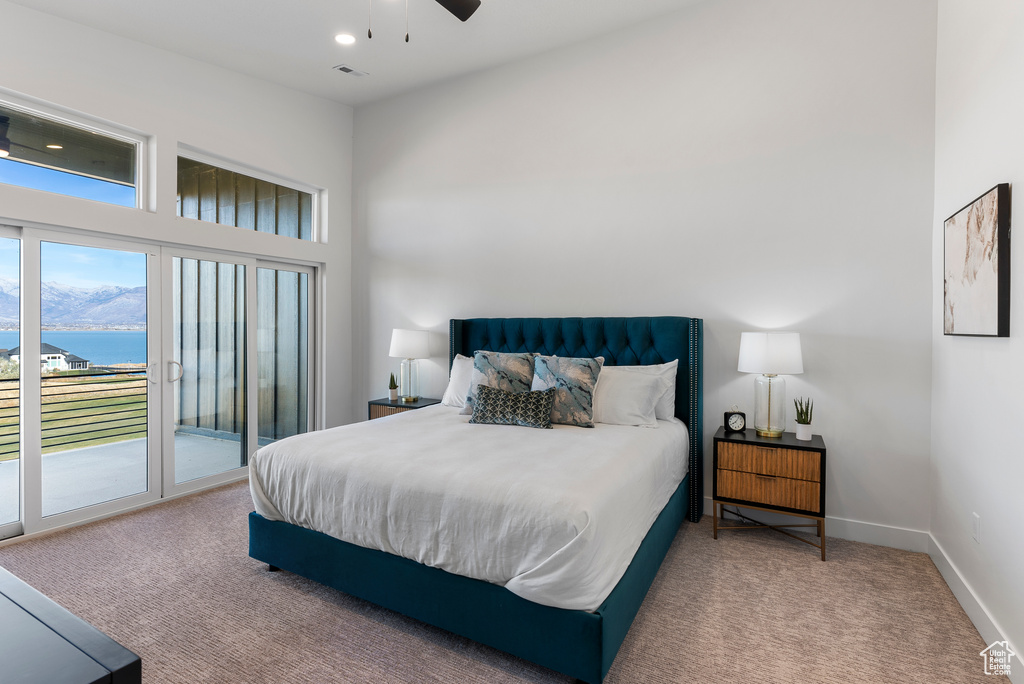 Bedroom with access to outside, carpet, a water view, and baseboards