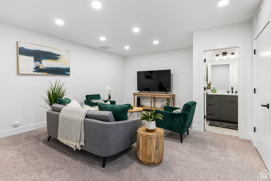 Carpeted living room with recessed lighting and bar area