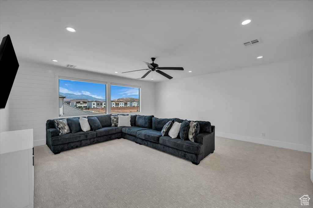 Carpeted living area featuring recessed lighting and ceiling fan