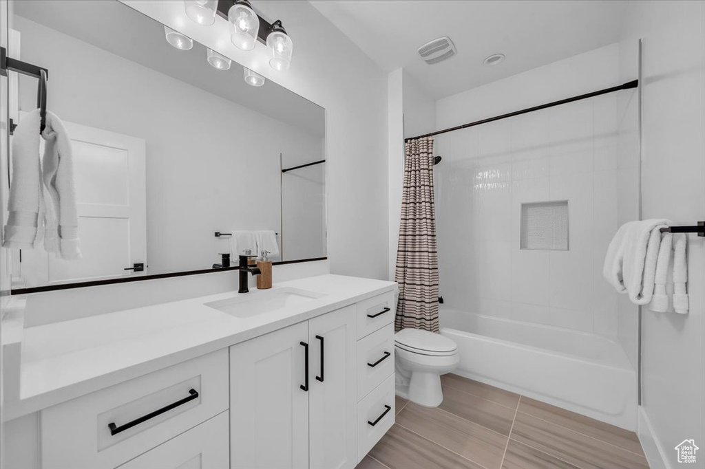 Full bathroom featuring vanity, shower / tub combo with curtain, and tile patterned floors