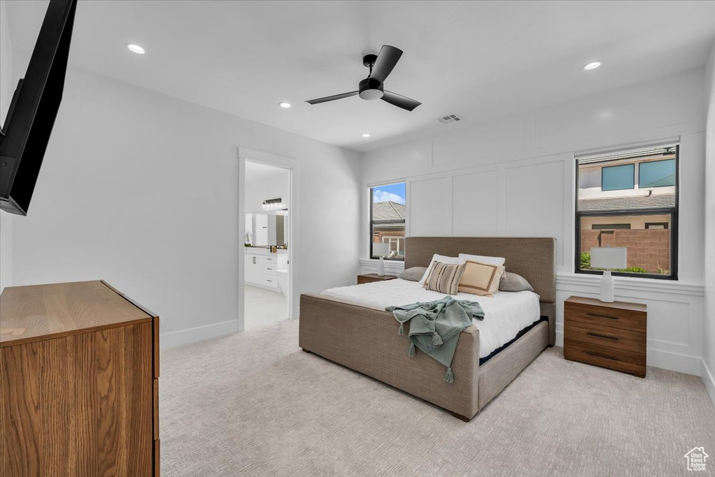 Bedroom with light colored carpet, recessed lighting, ensuite bathroom, and a ceiling fan