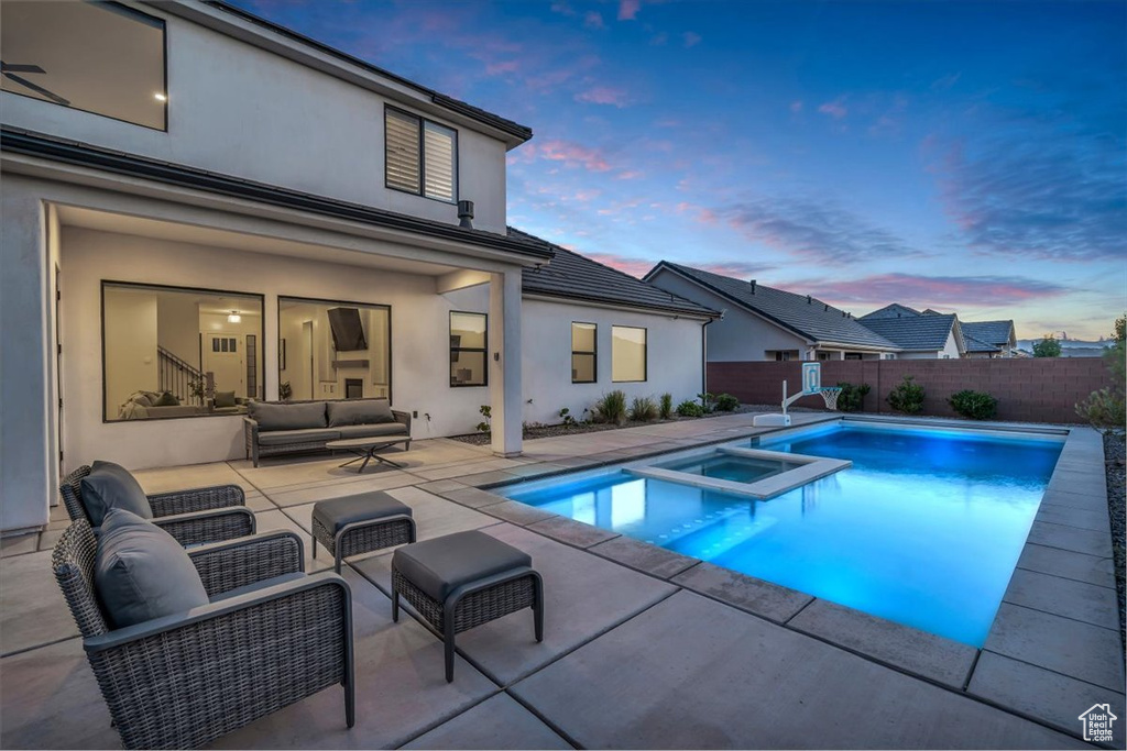 View of pool featuring outdoor lounge area, a patio area, a pool with connected hot tub, and a fenced backyard