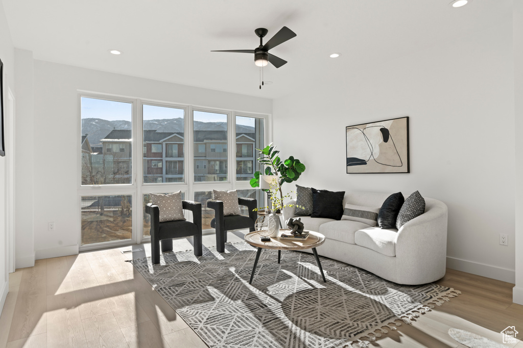 Living area featuring light wood-type flooring, a ceiling fan, and recessed lighting