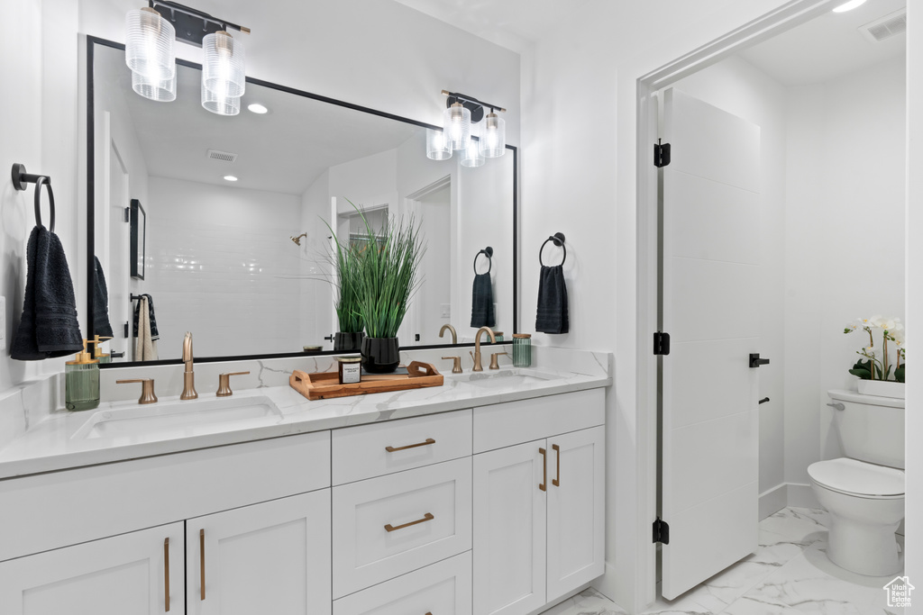 Full bath featuring double vanity, marble look tile flooring, recessed lighting, and a shower