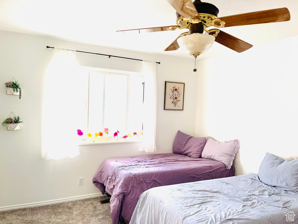 Carpeted bedroom with baseboards and a ceiling fan