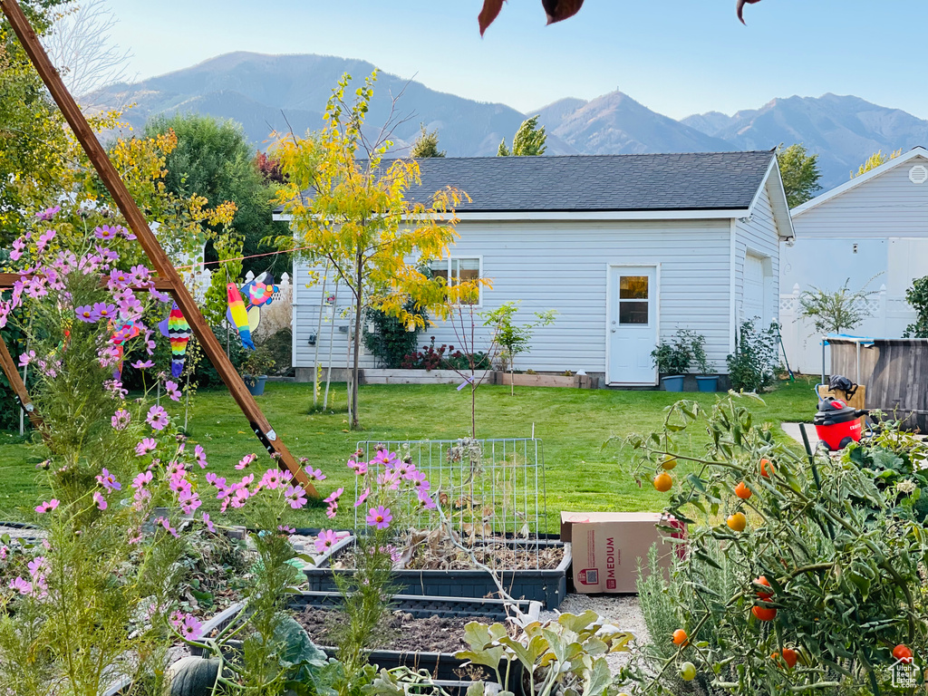 Rear view of property featuring a garden and a mountain view