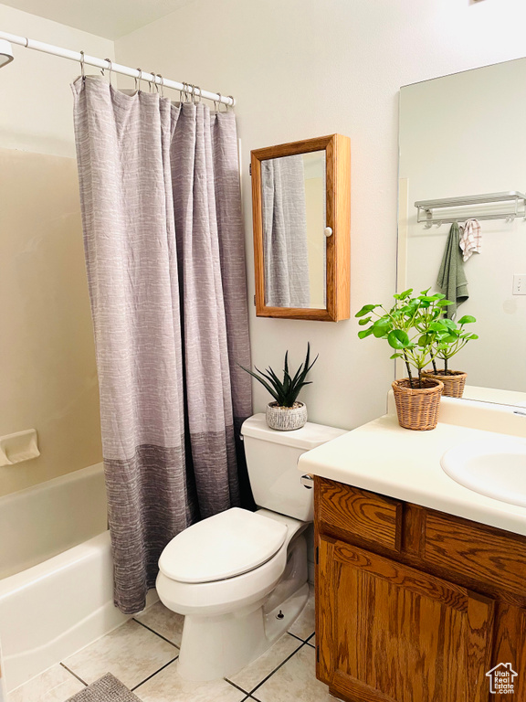 Bathroom with tile patterned floors, vanity, and shower / bathtub combination with curtain