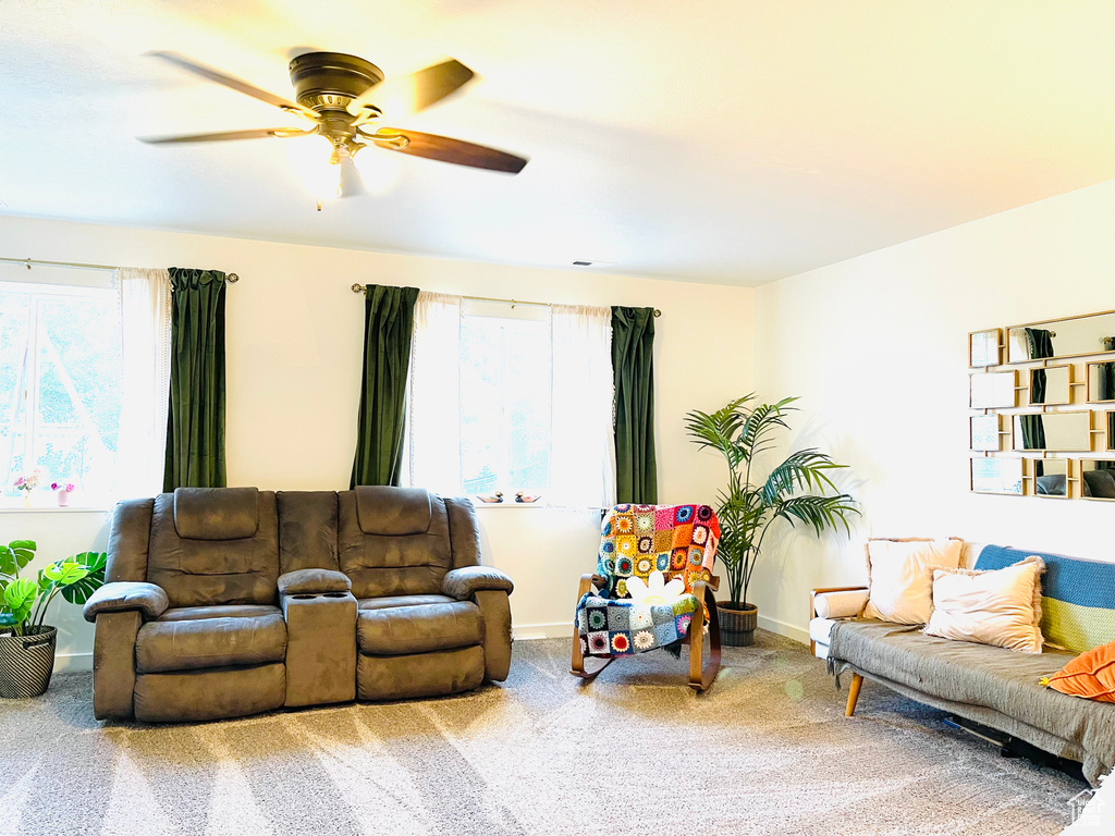 Living room with carpet floors, ceiling fan, and plenty of natural light