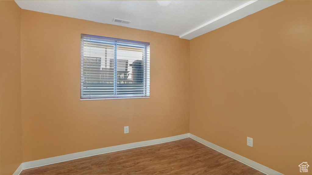 Unfurnished room featuring baseboards and wood finished floors