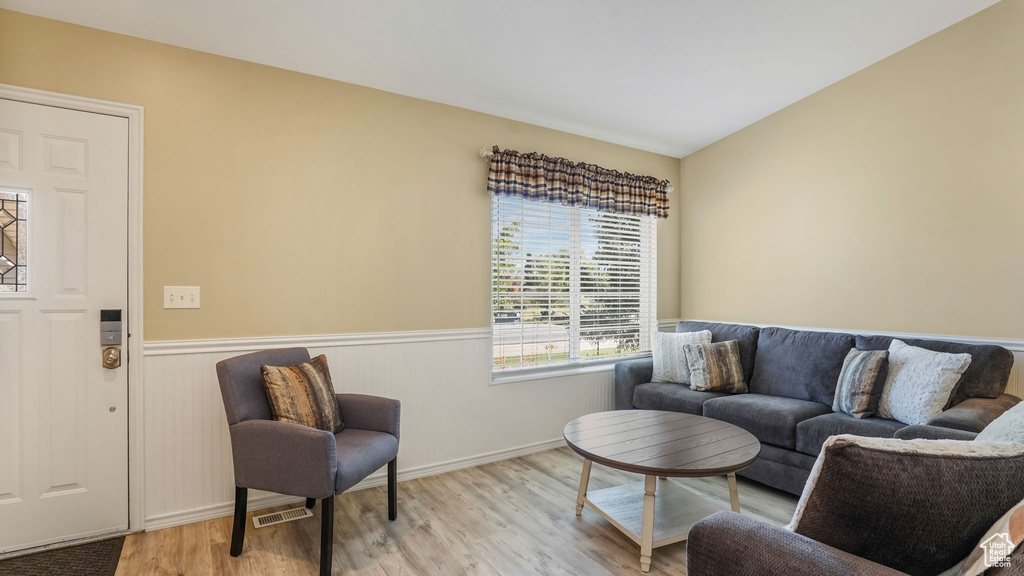 Living room with wood finished floors and a wainscoted wall