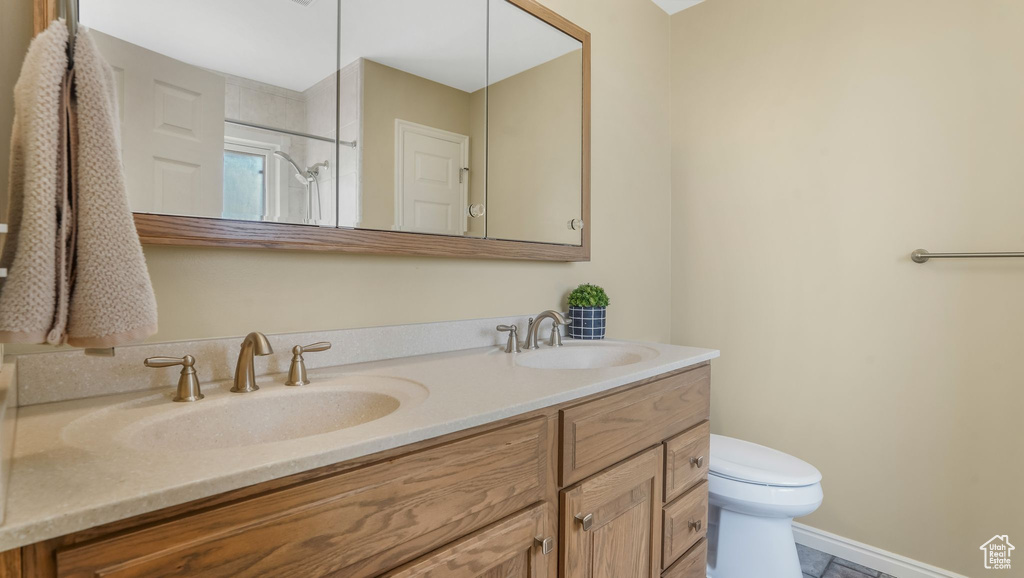 Full bath with double vanity, a shower, and tile patterned flooring