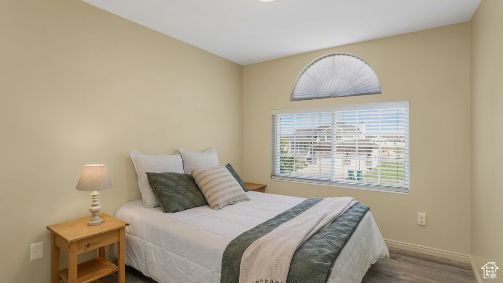 Bedroom with wood finished floors and baseboards