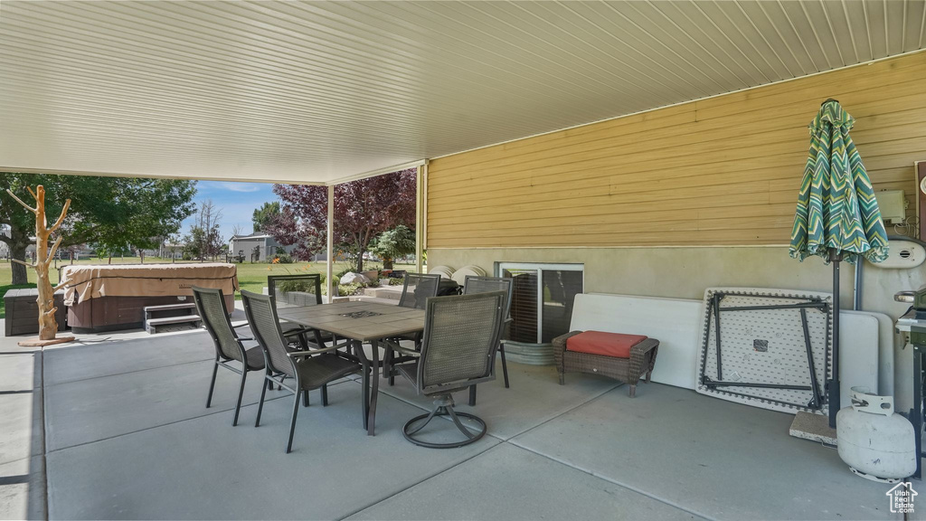 View of patio / terrace with a hot tub and outdoor dining area