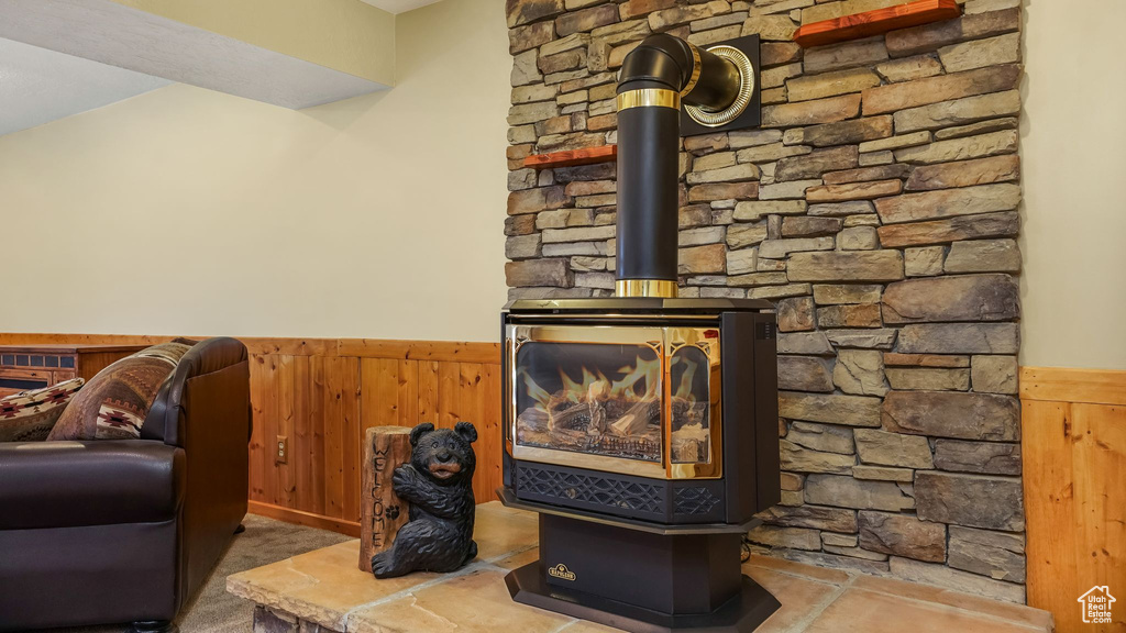 Detailed view of a wainscoted wall, a wood stove, and wood walls
