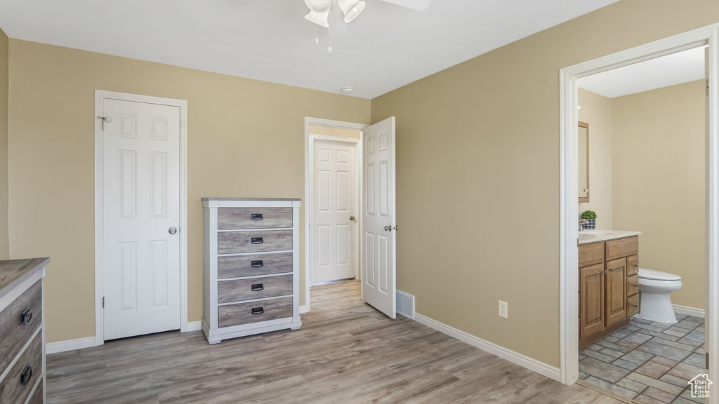 Bedroom featuring connected bathroom, light wood-style flooring, and a ceiling fan