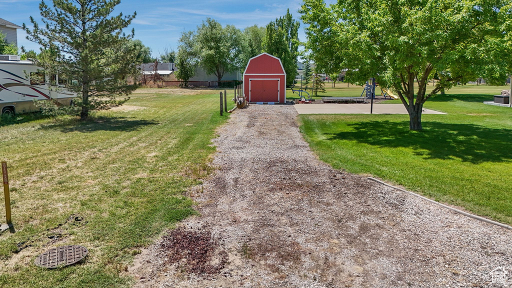 View of grassy yard with an outdoor structure and a barn