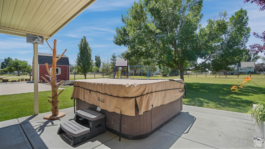 View of patio / terrace featuring a hot tub and a playground
