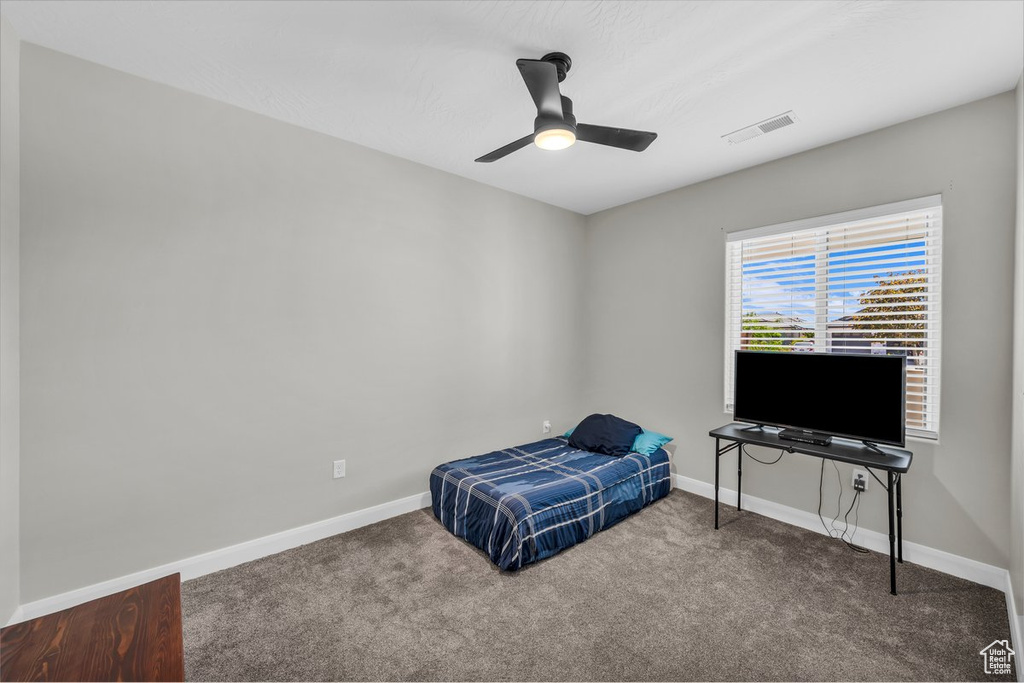 Carpeted bedroom featuring baseboards and ceiling fan