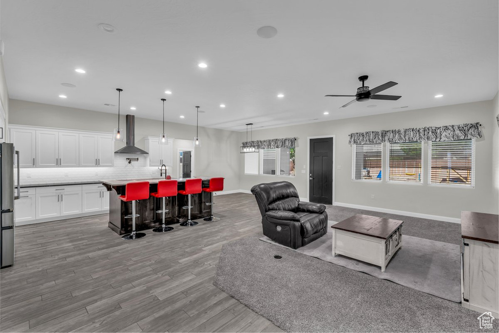 Living area with recessed lighting, plenty of natural light, light wood-style floors, and a ceiling fan
