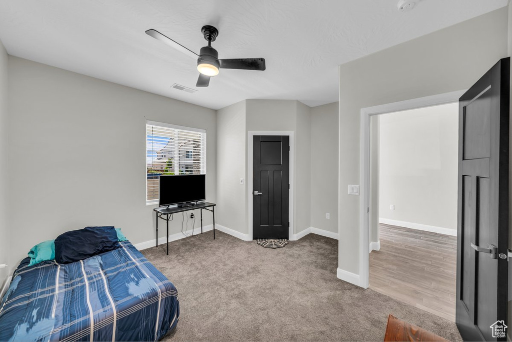 Carpeted bedroom featuring baseboards and ceiling fan