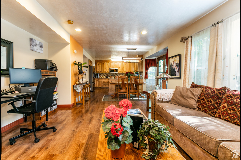 Living room featuring wood finished floors, a desk, and recessed lighting