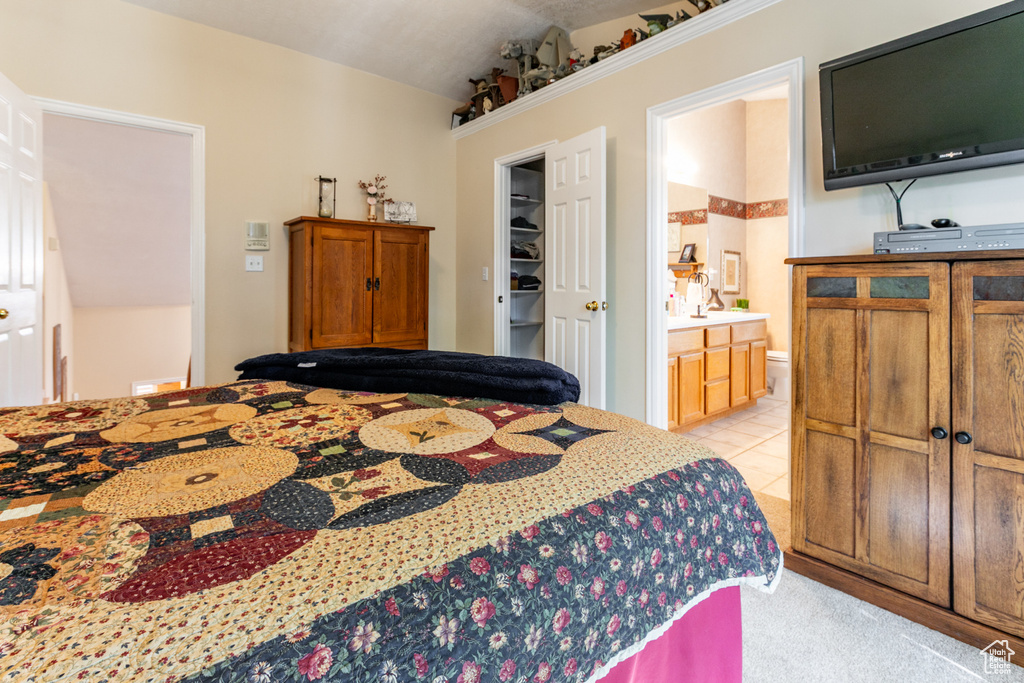 Bedroom featuring ensuite bath and a walk in closet