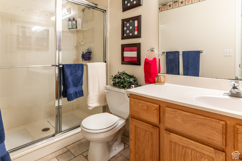 Bathroom with vanity, a stall shower, and tile patterned flooring