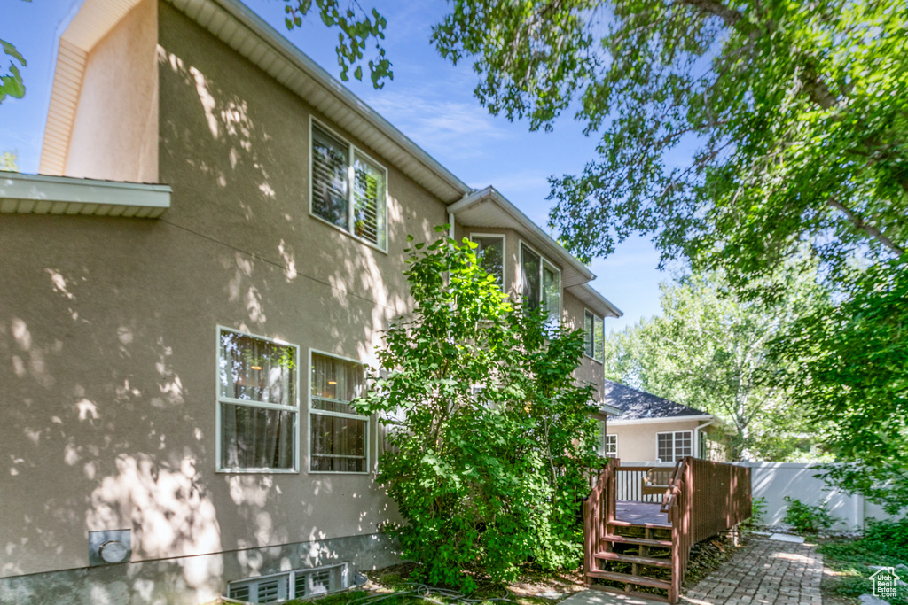 View of side of home featuring stucco siding and a deck