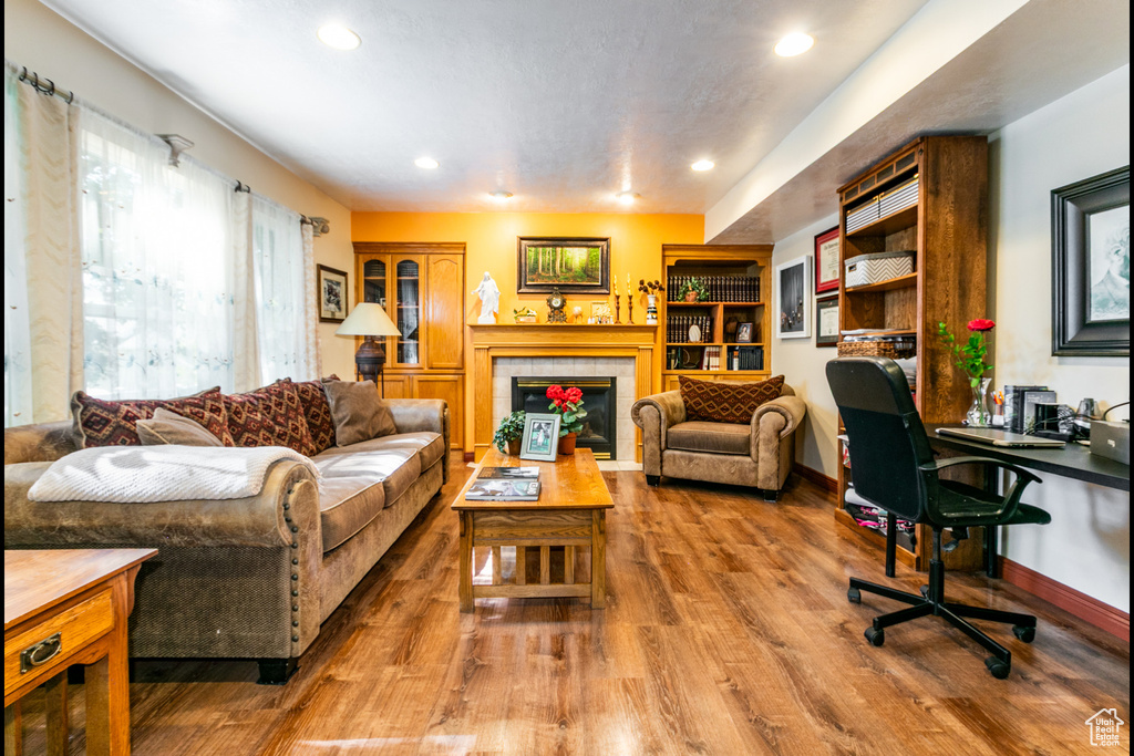 Living area featuring a tile fireplace, recessed lighting, wood finished floors, and an office area