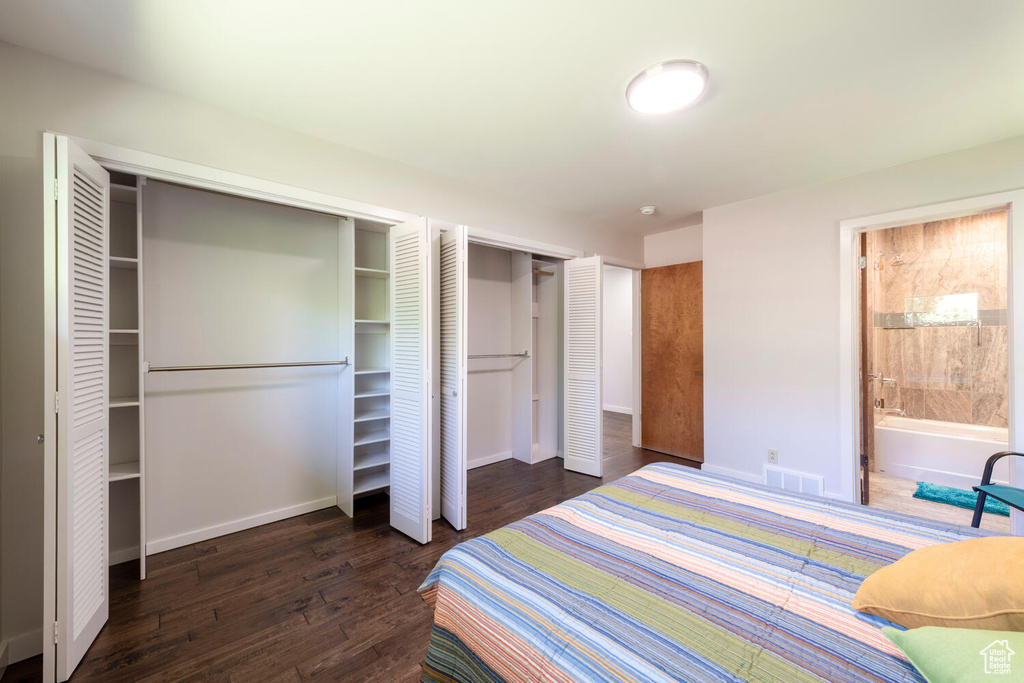 Bedroom featuring wood finished floors, multiple closets, and ensuite bathroom