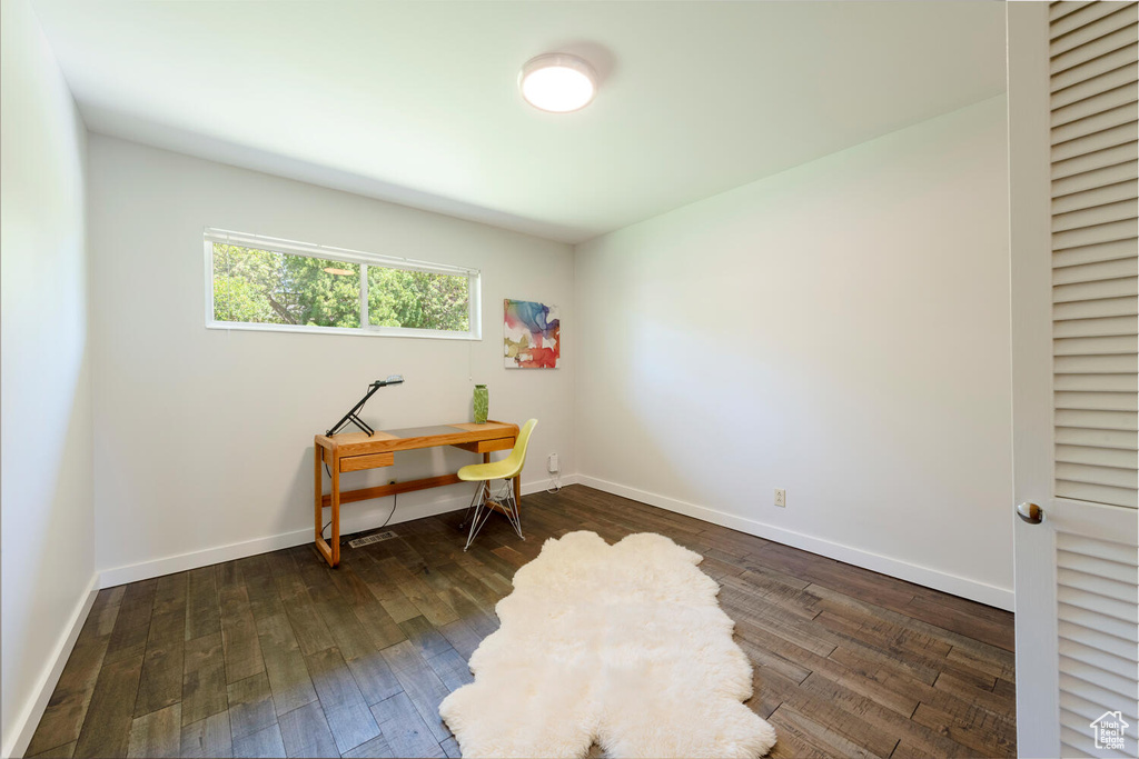 Office with dark wood-style floors and baseboards