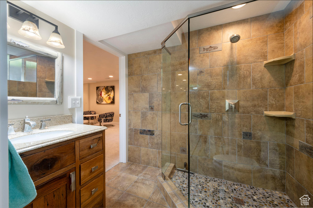 Bathroom featuring a stall shower, vanity, and recessed lighting