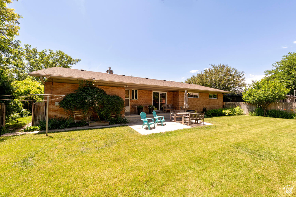 Back of property featuring brick siding and a patio area
