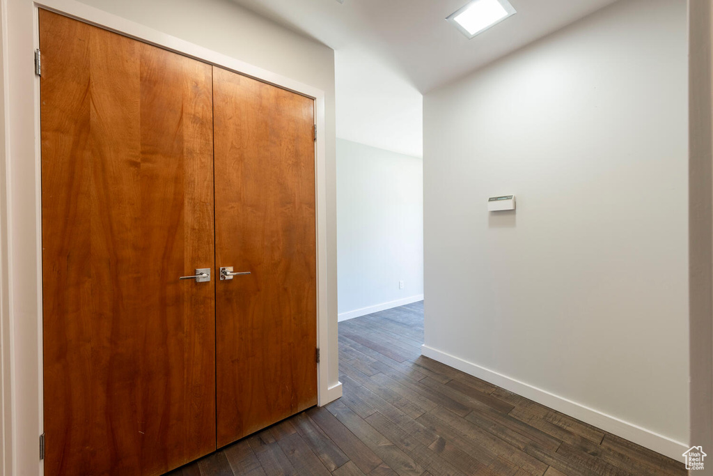 Hallway featuring dark wood finished floors and baseboards