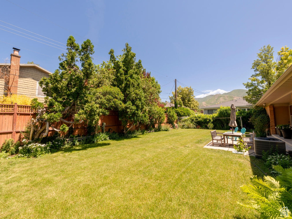 Fenced backyard featuring a patio area, an outdoor hangout area, and a mountain view