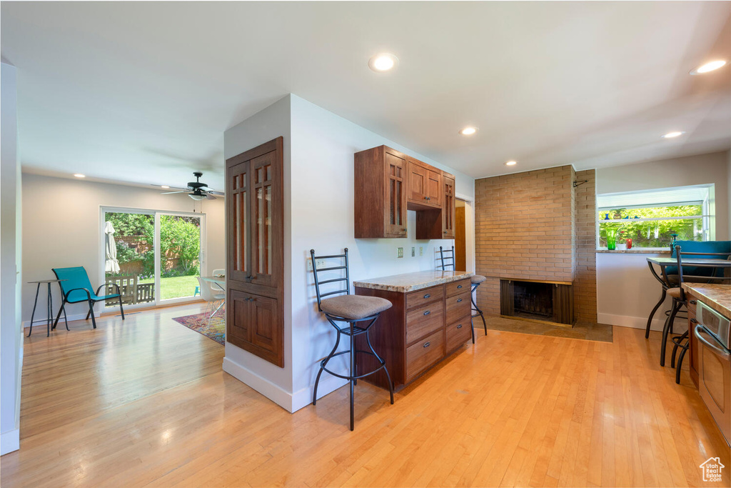 Kitchen featuring plenty of natural light, brown cabinets, light wood finished floors, and recessed lighting